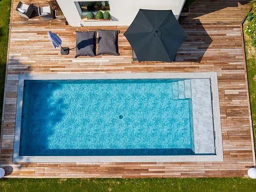 Vista dall'alto di una piscina rettangolare con pavimentazione in legno
